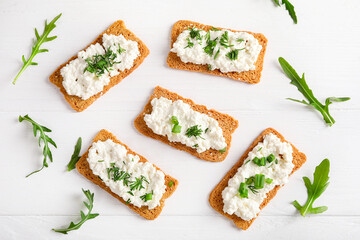 Healthy and tasty snack with crispy bread, cottage cheese and herb