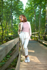 A beautiful woman posing on a wooden bridge in a Park