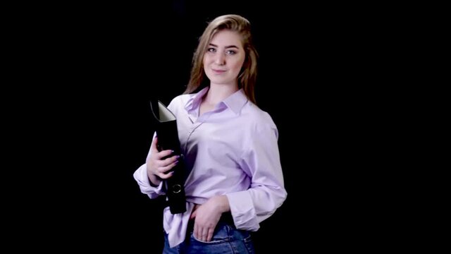 Beautiful young  businesswoman in a blue shirt with document case on black background. The business, office, work concept