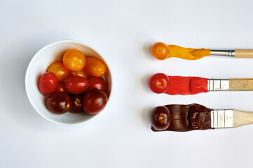 tomatoes in a plate and paints with brushes