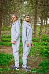 Beautiful, young guys in tracksuits play sports in the park outdoors. Healthy lifestyle.