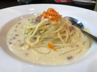 Spaghetti cream sauce bacon ham and mushroom in original pasta bowl on plate. Italian food style