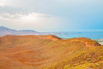  panoramic view of Volcano Montana Roja de Playa Blanca, Lanzarote, Spain. One of the most popular volcano in Canary Islands and the total view of the village in the south with white houses. 
