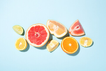 Mix of citrus fruits on blue background.