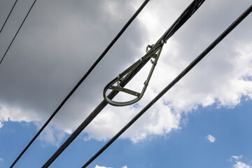 Bracket of a snowshoe bend limiter for fiber optics against a blue sky with clouds, horizontal...