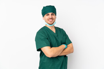 Surgeon in green uniform isolated on isolated white background with arms crossed and looking forward