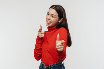 Photo of cheerful young woman winking and pointing fingers at camera