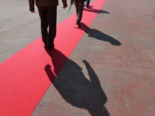 Walking persons  on red carpet close view on legs