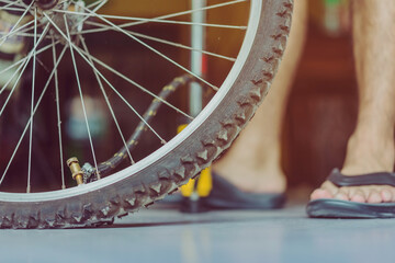 Close-up of a young man prepare to pumping the old bicycle wheel in his home. .