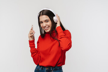 Photo of happy woman smiling while using cellphone and headphones