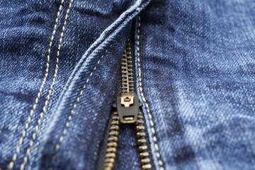 Macro close up of isolated blue casual denim jeans pants with metal teeth zipper