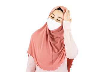 Young muslim asian woman with traditional dress wearing medical face mask  under the outbreak of the virus,Have a headache isolated on white background