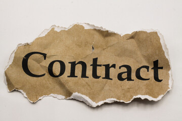 Cancelled agreement concept: Close up of isolated crumpled piece of scrap paper with word contract, white background