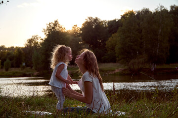 Fototapeta premium Daughter and mom are hands together. The family is happy. Smiles and laughter. They look at each other.