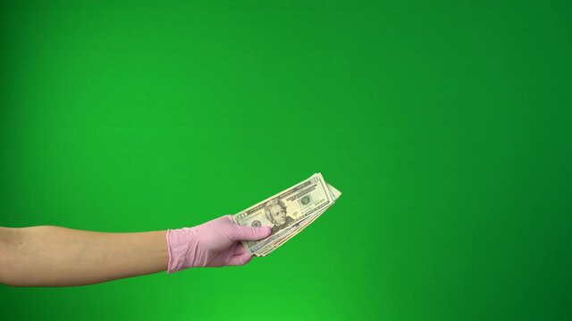 The persone in protective medical gloves gives the dollars. Coronavirus pandemic (Covid-19). Chroma key, Isolated chromakey background, Green screen. Preventative measures
