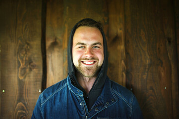 Fototapeta premium Young man in front of wooden wall