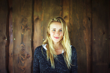 Fototapeta premium Young woman in front of wooden wall
