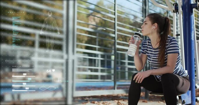 Fitness girl drinks from a sports bottle. Smart technology mobile app health sport tracker virtual diagram screen display DNA cardio health information analysis report.
