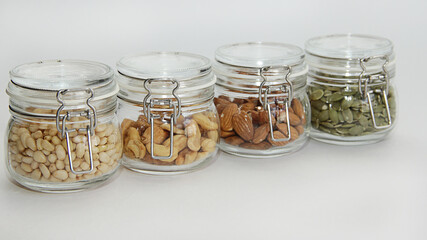 glass jars with nuts on a white background