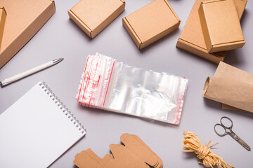 Lot of zip lock bags and brown cardboard boxes on grey background © mdbildes