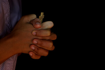 Obraz premium Human hand holding the cross black background