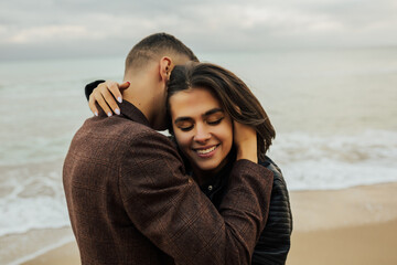 Happy romantic  travel couple enjoying beautiful time at sea, walk on the beach. Travel. Vacation. Lifestyle. Young couple in love. Attractive man and woman enjoying romantic day.  Close up.