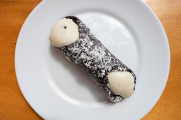 Chocolate Cannoli on a White Plate on a Wooden Table