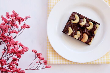 Delicious brownies on white cup for breaking fasting, flower Component and Marble floor.