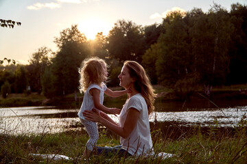 Daughter and mom are hands together. The family is happy. Smiles and laughter. They look at each other.