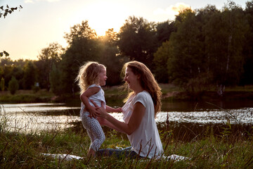 Fototapeta premium Daughter and mom are hands together. The family is happy. Smiles and laughter. They look at each other.