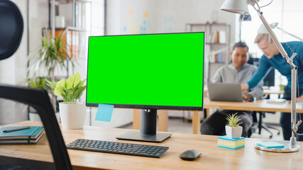 Mock-up Screen Desktop Computer Standing on the Desk in the Modern Creative Office. In the...