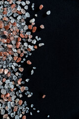 Pink himalayan crystal salt on black background. Handful of salt. Vertical background wallpapers. Beautiful rock salt crystals on dark background