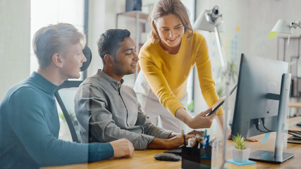 Talented Entrepreneur Working on His Desktop Computer with Project Manager and Team Leader Standing...