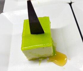 Close up of a slice of chocolate sour cream cake with a slab of chocolate on top