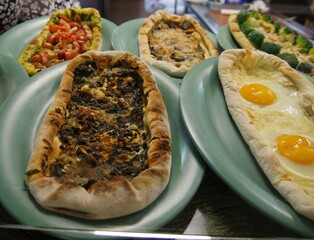 Medium close up of an assortment of pizza breads with various toppings
