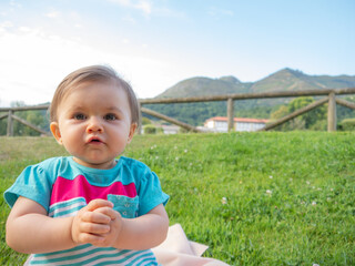 Fototapeta premium Cute little baby sitting in the grass