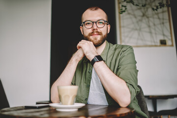Fototapeta na wymiar Handsome young man in eyeglasses resting in cafe