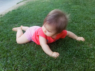 Fototapeta premium Cute little baby playing in the grass