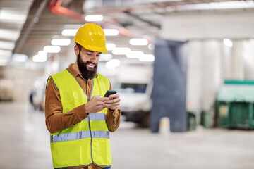 Young smiling bearded construction worker standing in underground garage in construction process...