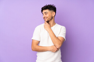 Arabian handsome man over isolated background looking to the side and smiling