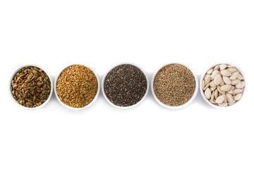 Assortment of different seeds in bowl isolated on white background. Pumpkin, linen, chia, sunflower, and sesame seeds. Top view