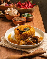 Indian Mutton Biryani Dish served on wooden table. Typical food from India, made from goat meat mixed with spices and basmati rice