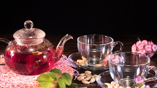 Teapot with red tea.Medicinal therapy on medicinal herbs and decoctions.Spicy herbs and medicinal broths.Relaxing and tonic drink.Zen tea ceremony. Hot luxury tea with a pleasant smell in a cozy home