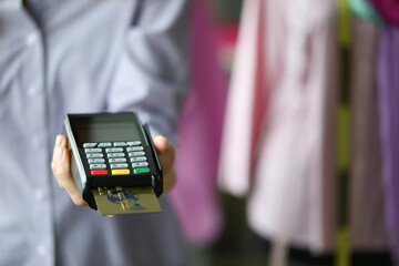 Close-up of person holding terminal with plastic credit card. Cashier machine to withdrawals...