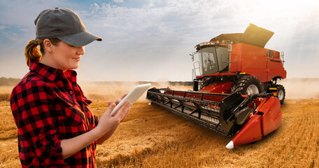 Woman farmer with digital tablet on a background of harvester. Smart farming concept. - obrazy, fototapety, plakaty