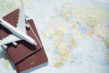 Passport with a map background.Travel planning.Top view of traveler accessories with a plane  on...