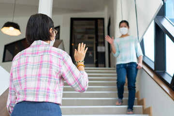 two asian woman are wearing face mask and making safe greeting during covid-19 or coronavirus outbreak to prevent infection. social distancing and new nomal lifestyle concept