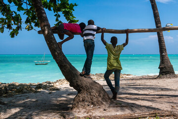 Zwarte Afrikaanse jongens die in de oceaan kijken op het strand van het dorp Nungwi in het noorden van Zanzibar, Tanzania