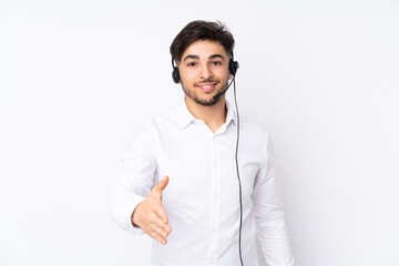 Telemarketer Arabian man working with a headset isolated on white background handshaking after good deal - obrazy, fototapety, plakaty