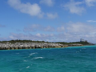 Stretch of rocky island with the blue waters of Exuma Cays, Bahamas. The site is popular for tourists.